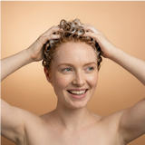 Woman with wet hair on a beige background